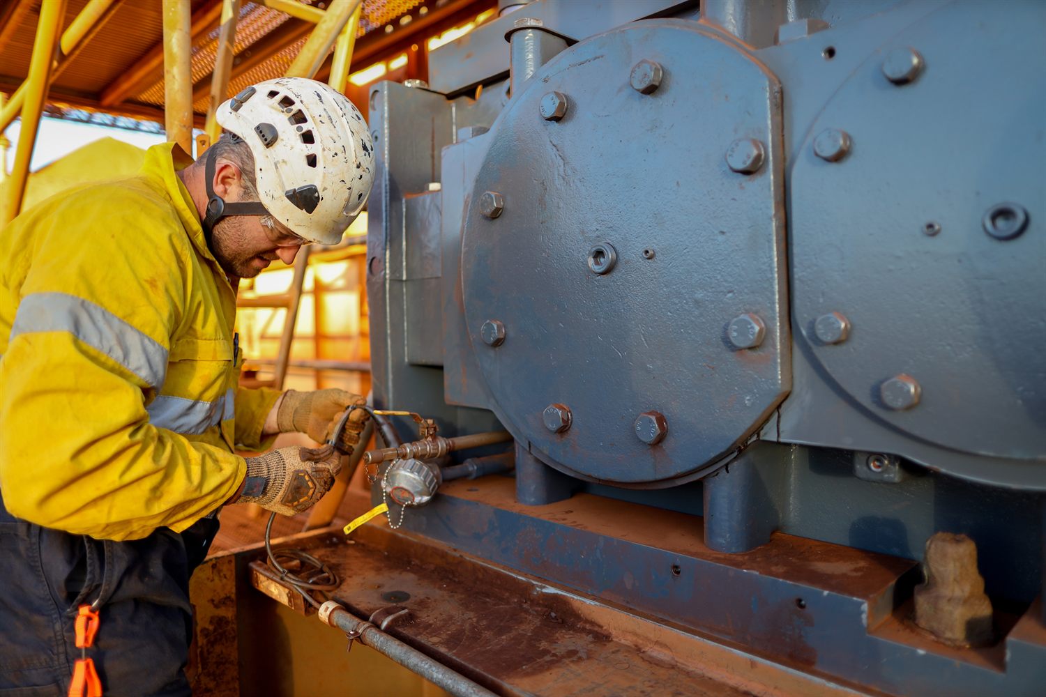 A maintenance technician in hi-vis servicing a slurry pump at an Australian minerals processing plant